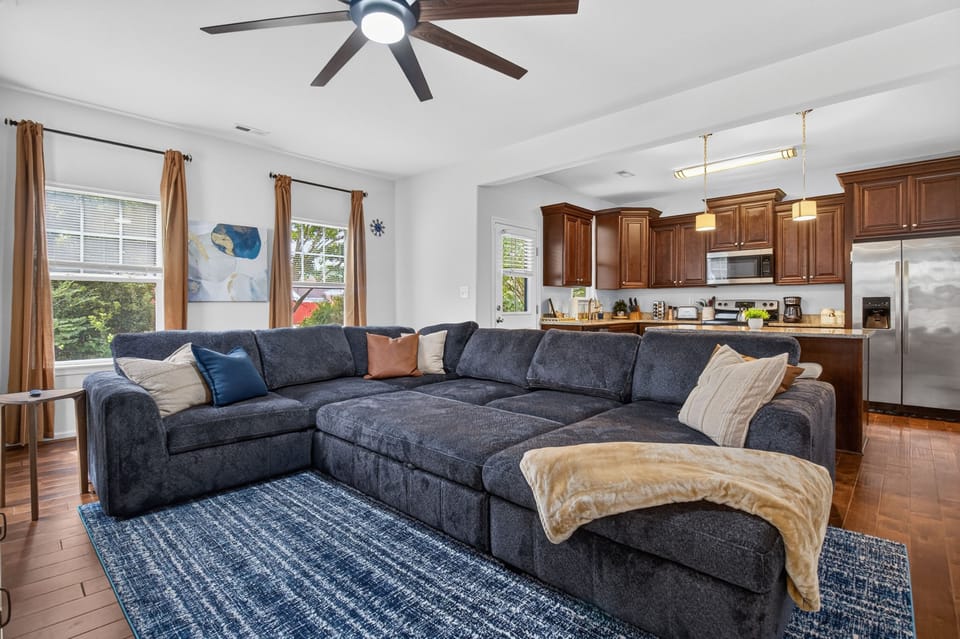 Spacious open living room with oversized sectional and bright full kitchen