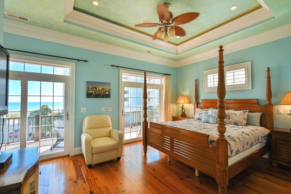 Masters bedroom A large wooden four-poster bed with patterned bedding