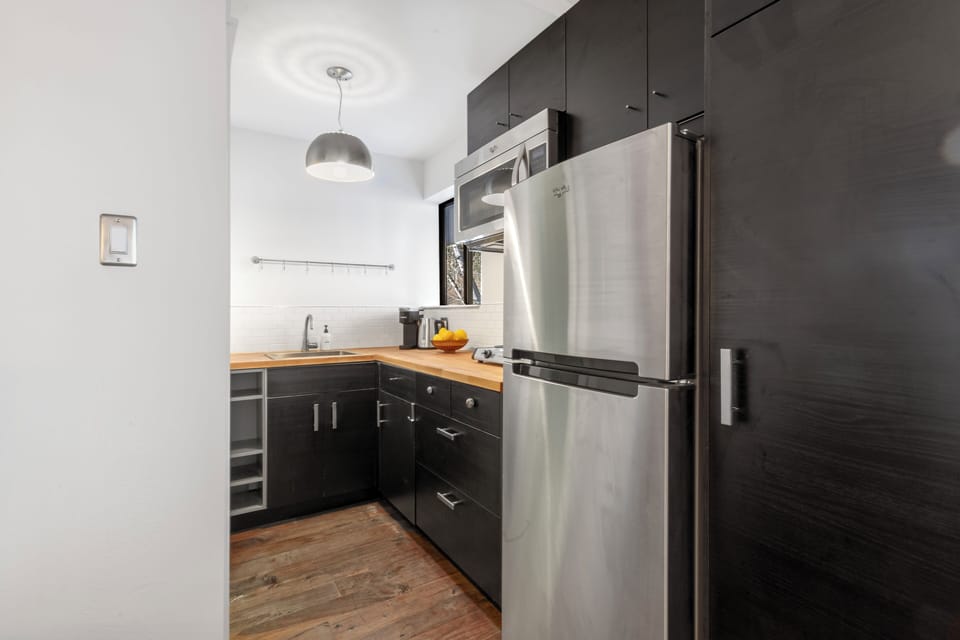 Galley Kitchen features full refrigerator, ample storage, microwave, hot plate and coffee and kettle.