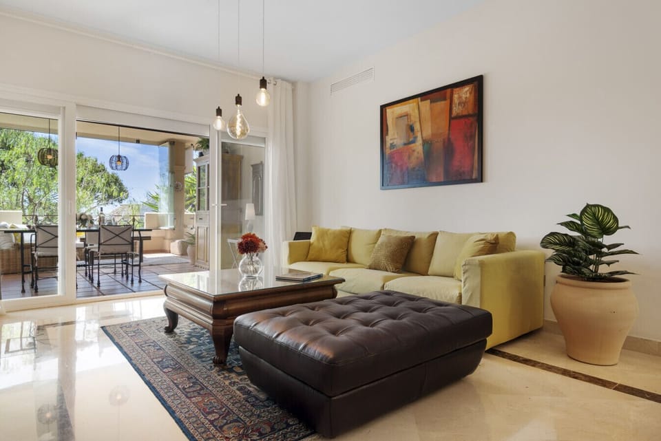 Spacious living room with large Smart TV, sound system, seating area, dining area, central AC