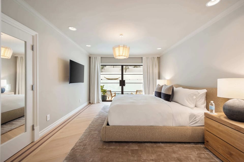 The primary bedroom offering natural light, plush bedding, and tranquil design elements.