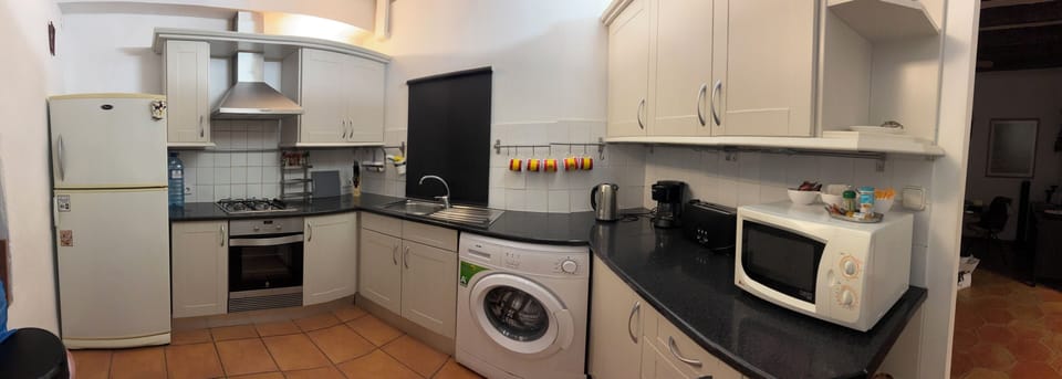 Kitchen, chasing machine, fridge freezer, microwave, kettle, toaster.