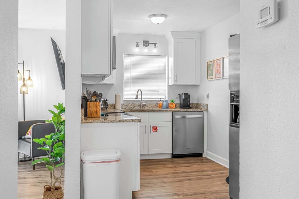 Compact kitchen with white cabinetry and stainless steel appliances.