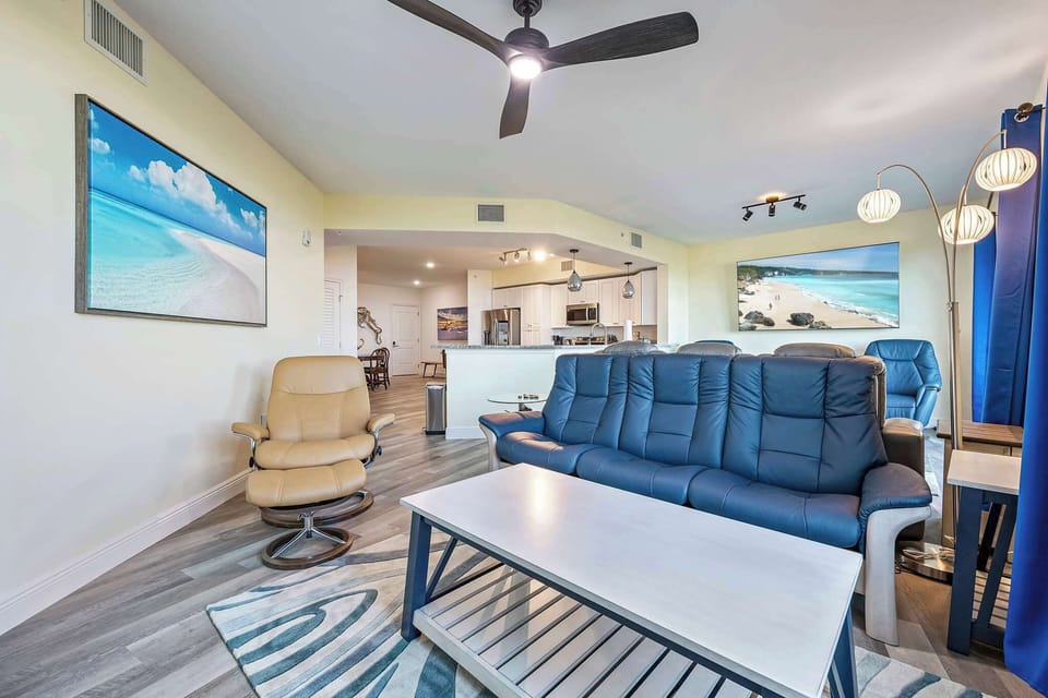 Open-concept living area with modern seating and coastal artwork.