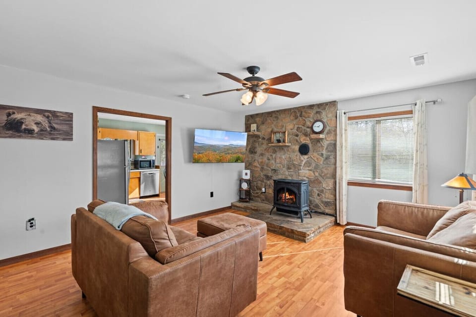 The living room includes a gas fireplace, large Smart TV, and plenty of comfortable seating.