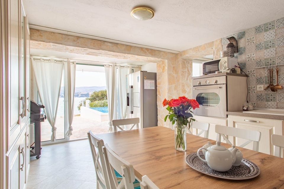 Fully equipped kitchen and dining area in Luxury Villa Destiny Ciovo 1 with heated pool at the beach
