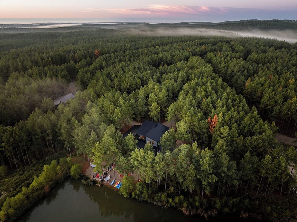 A breathtaking drone shot at sunrise, showcasing the cabin’s idyllic setting among endless pine trees. The Cove is the perfect retreat for those seeking peace, serenity, and outdoor adventure.