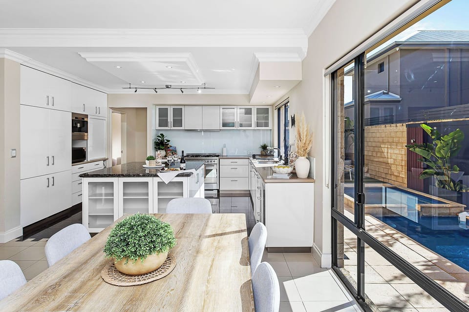Enjoy the sleek kitchen with Miele appliances, flowing to dining with pool views.