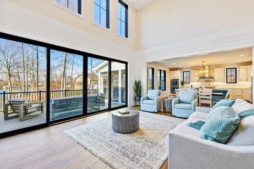A bright and open living space with comfortable seating, high ceilings, and seamless flow into a modern kitchen and dining area.
