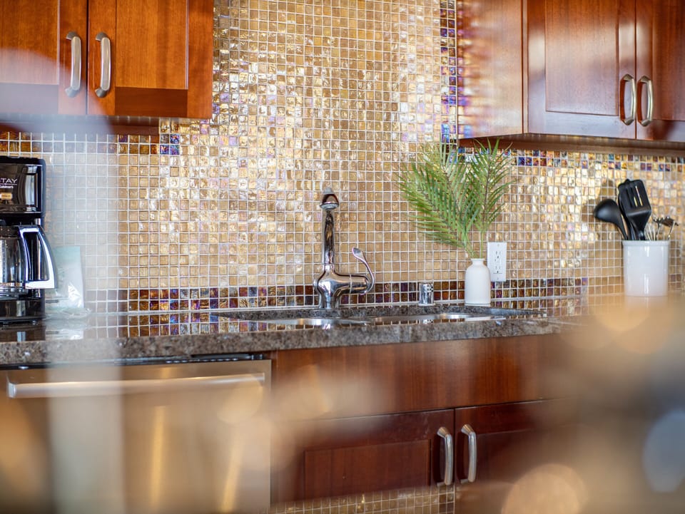 Add a splash of style to your stay with this beautifully designed mosaic backsplash and modern kitchen setup.