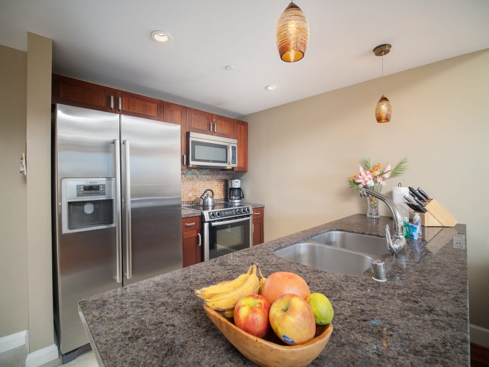 Prepare meals in a modern kitchen with sleek stainless steel appliances, granite countertops, and stylish pendant lighting—perfect for family gatherings or group vacations.