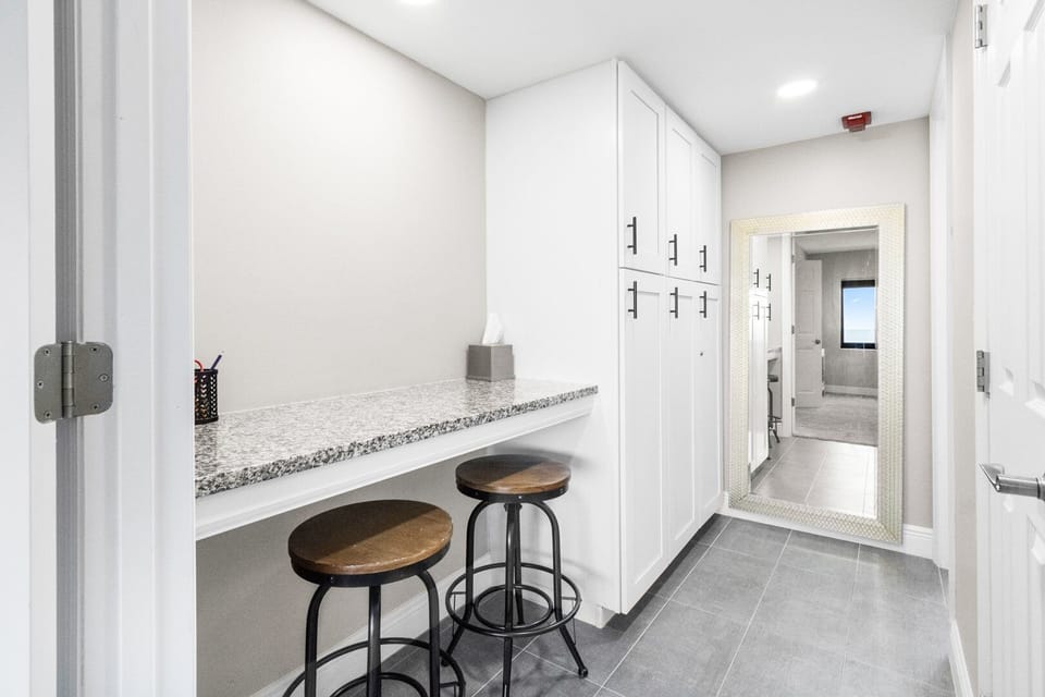 Stylish seating area with barstools and storage cabinets.
