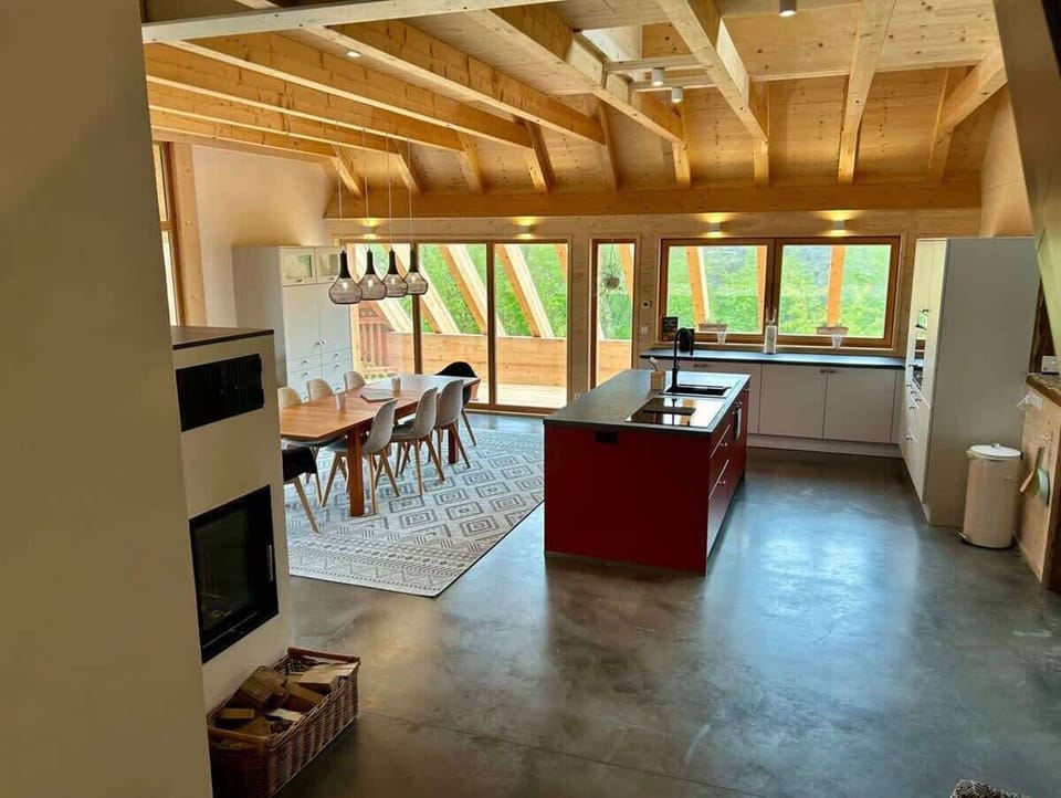 Eine vollausgestattete Küche mit hochwertigen Geräten und einer eleganten roten Insel. Hier treffen Design und Funktion aufeinander: luxuriös, stilvoll und perfekt für kulinarische Kreationen. Ein Raum, der Kochen zum Erlebnis macht!