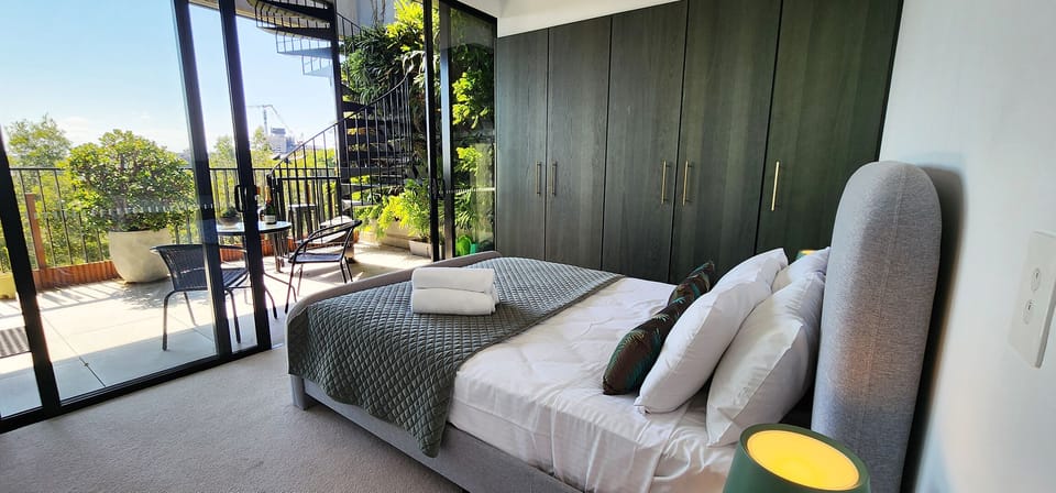 Queen bedroom with built-in wardrobes and direct access to balcony. Air con