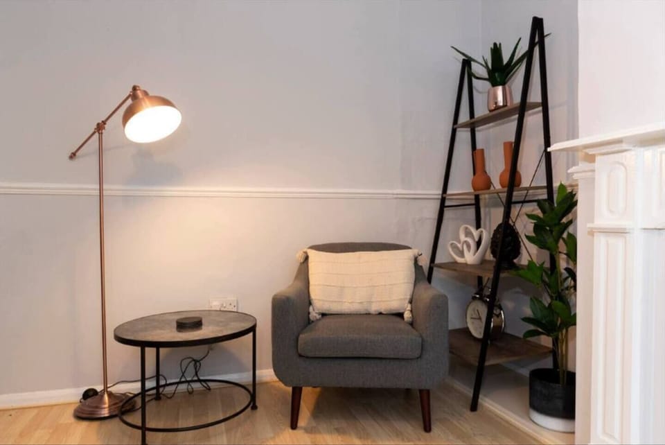 Cozy up in this charming reading nook, featuring a comfy armchair, warm lighting, and stylish decor—perfect for relaxing with a good book.
