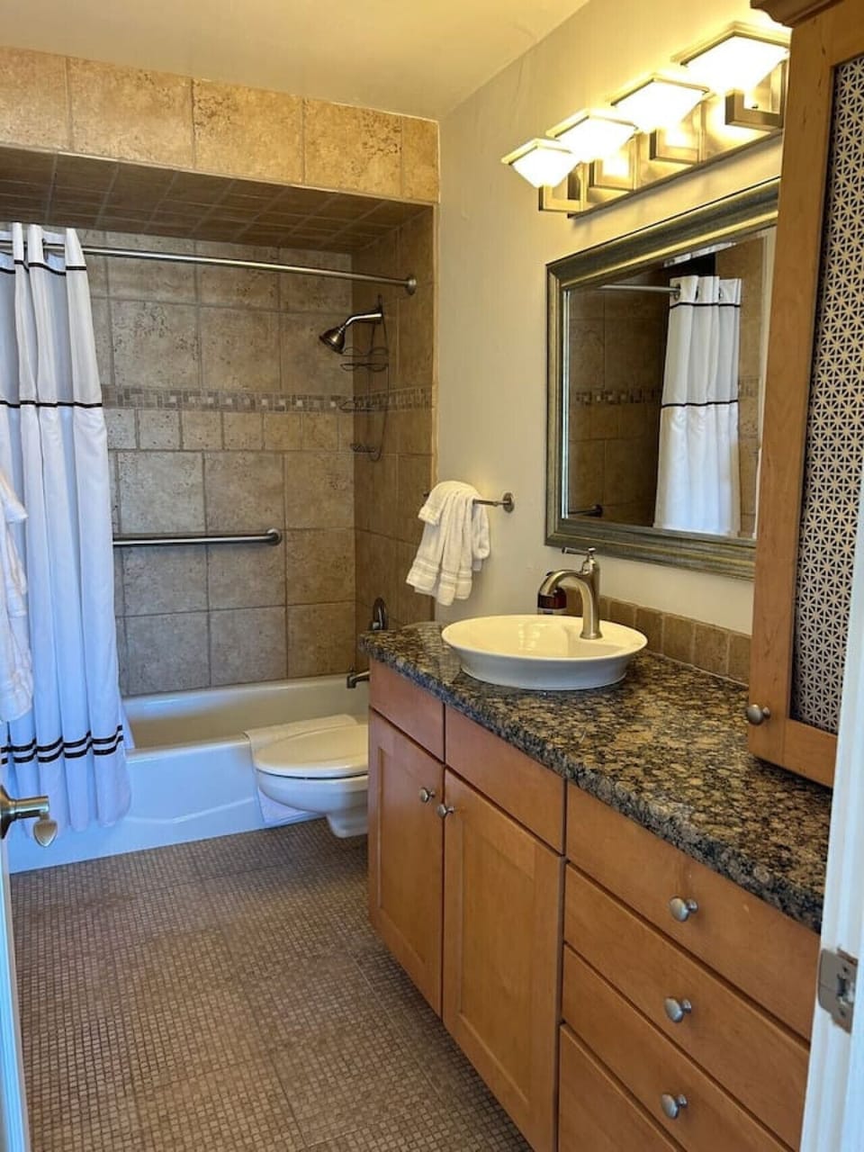 Beautiful stone counters and tiles make for a relaxing space to unwind or get ready for your day