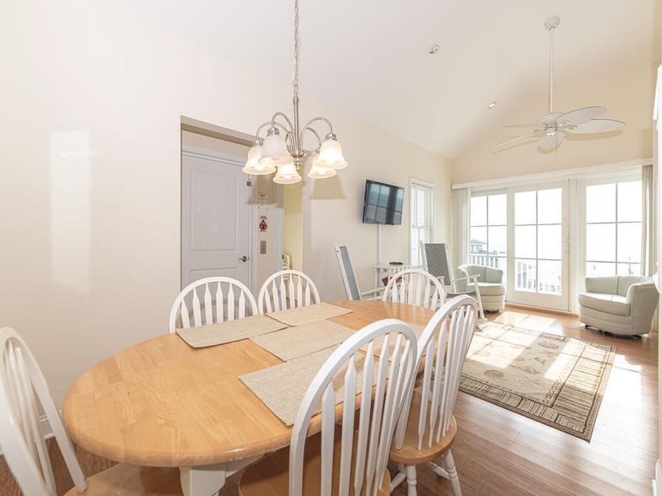 The cozy dining area invites conversation with its warm lighting and comfortable seating for six.