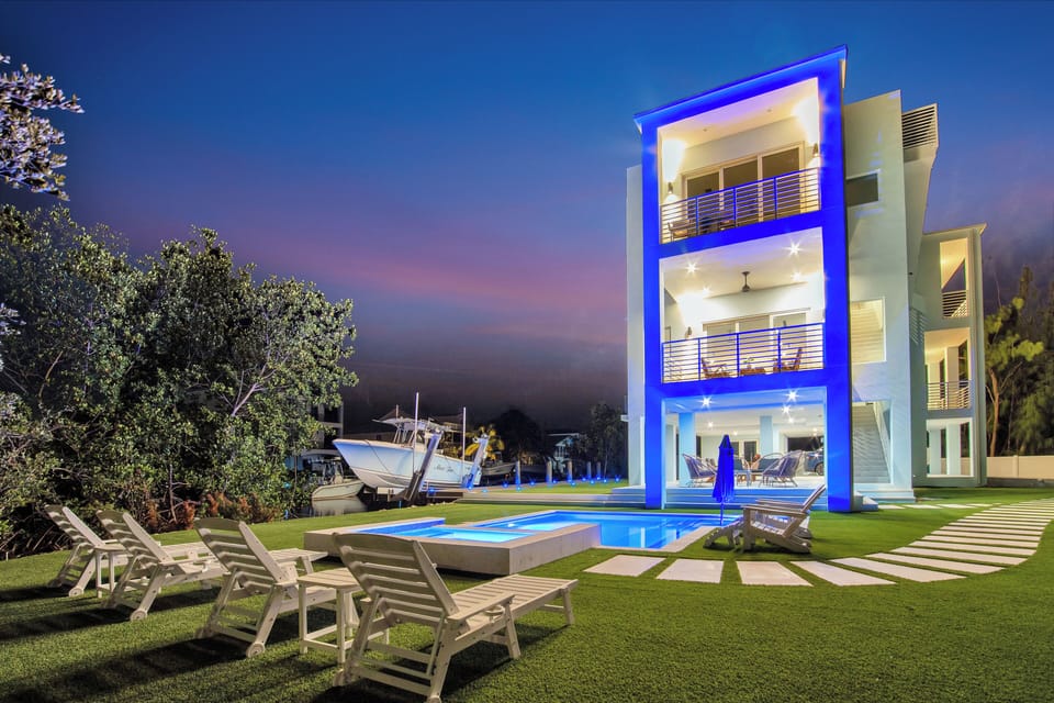 Backyard | An outdoor paradise with a private dock, heated pool, putt-putt, bbq grill and ample seating.