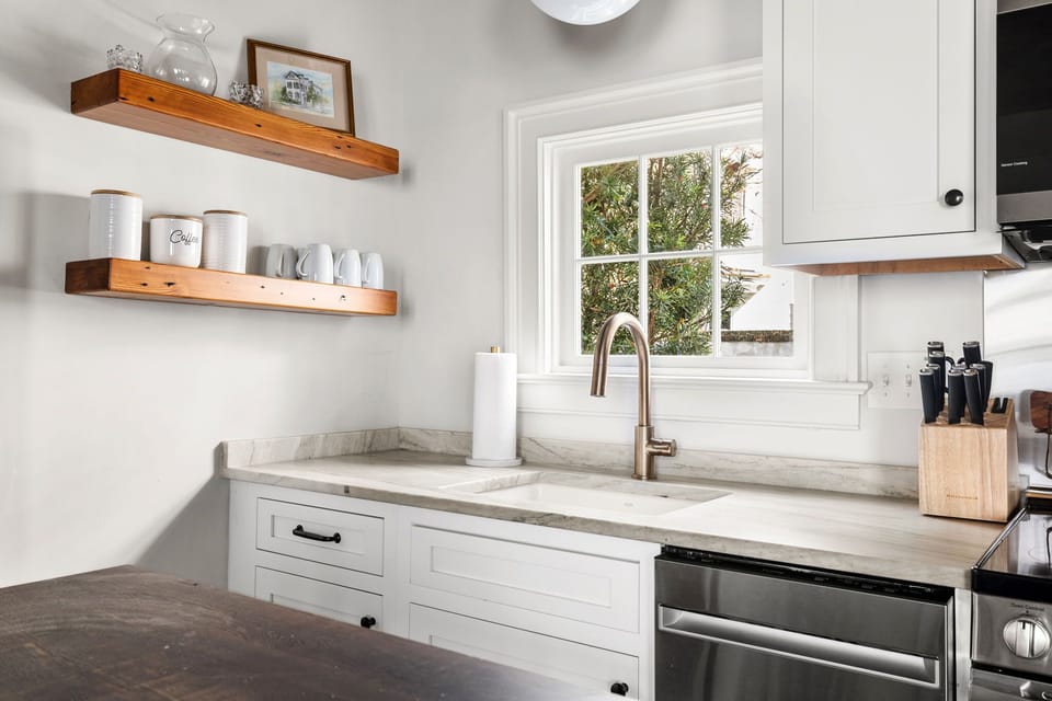 The sink features a small window behind it, allowing natural light to filter in and brighten the space.