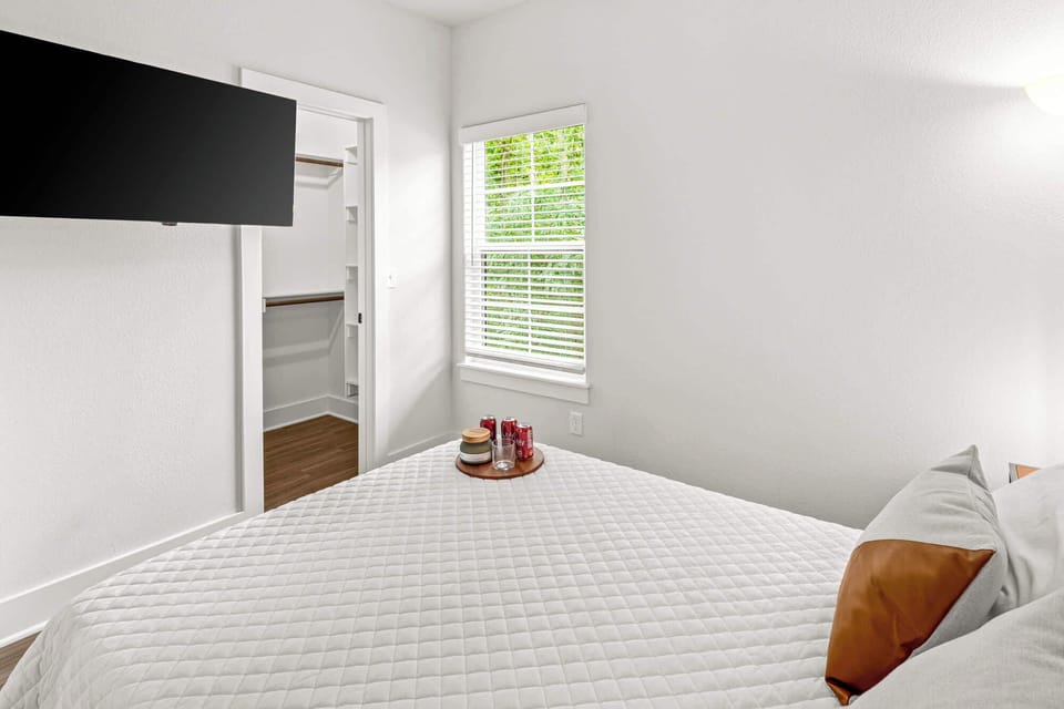 Cozy bedroom with double bed, smart TV and window view—unwind in comfort after a day exploring Fayetteville.