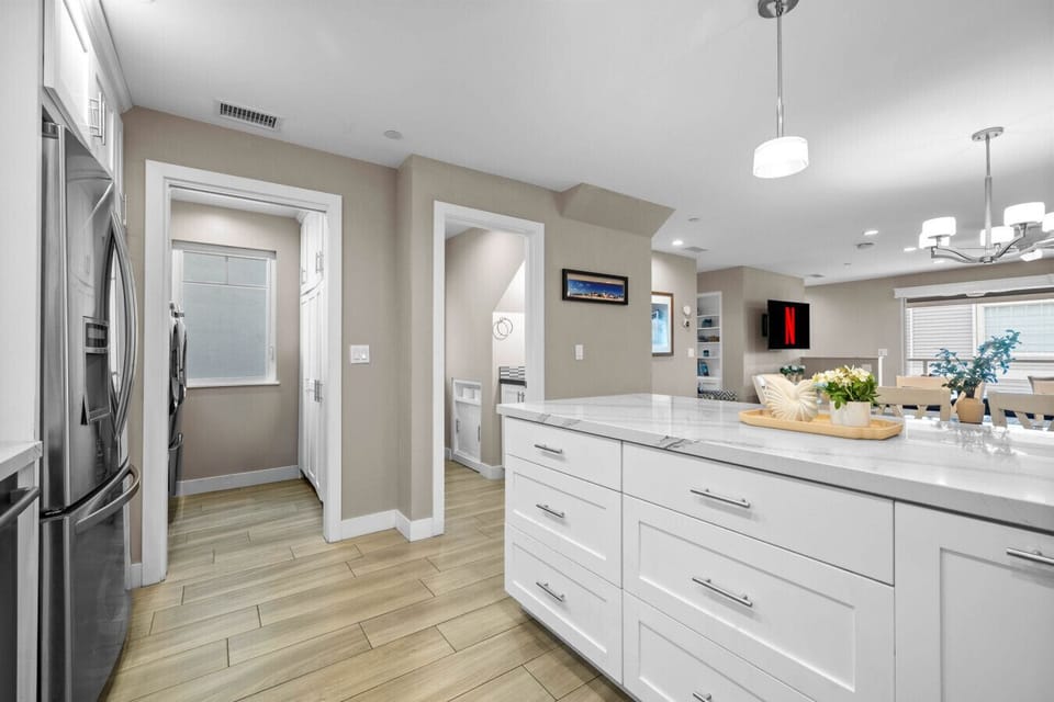 Open-concept living with island seating, Netflix-ready TV, and laundry just off the kitchen. 🎬🧺🍽️