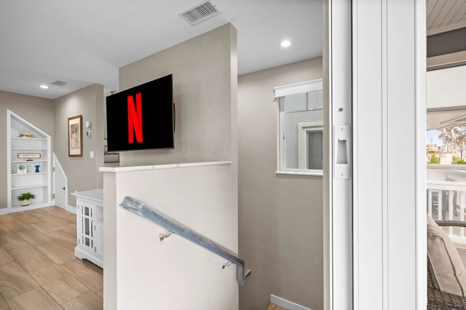 Second-floor entry with smart TV, built-in shelving, and easy balcony access. 📺🚪✨
