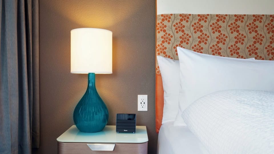 Unwind under warm bedside lighting with crisp, inviting linens.