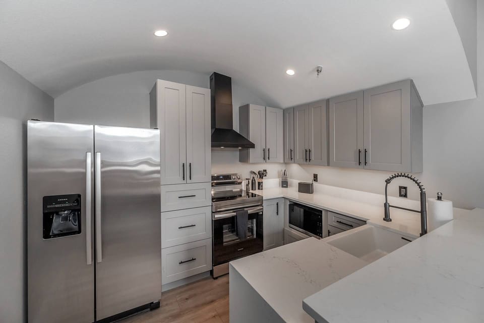 The gorgeous kitchen with modern touches has plenty of counterspace and comes fully stocked with essentials and stainless-steel appliances