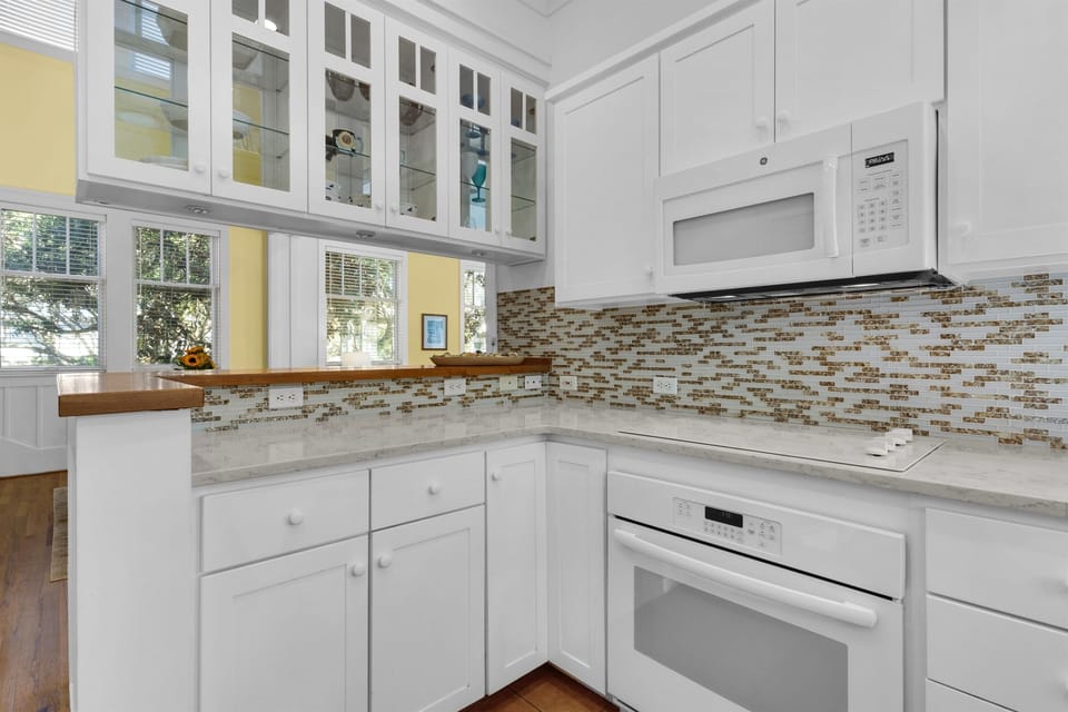Cook your favorite meals in this bright, fully-equipped kitchen with modern appliances and elegant mosaic tile backsplash.