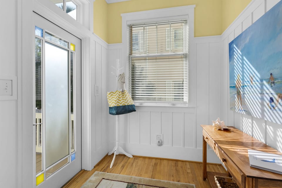 Unwind in your bright, cheerful mudroom where natural light streams through charming windows, creating the perfect spot to drop your bags after beach adventures.