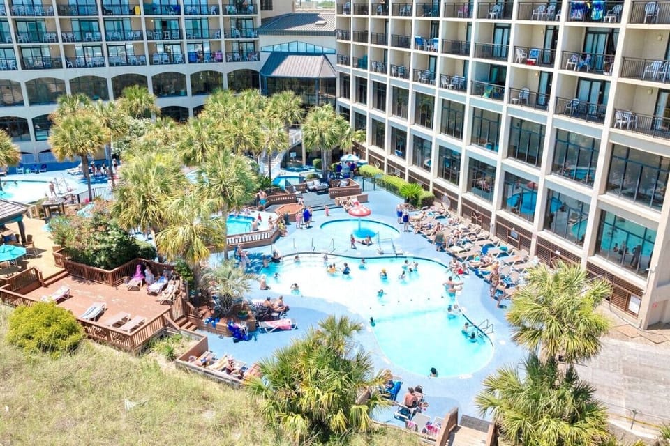 Luxurious beachside resort with a sparkling pool, relaxing hot tubs, and a lively poolside bar. Surrounded by palm trees and overlooking the ocean, this tropical oasis offers sun loungers, refreshing drinks, and direct beach access for max relax.