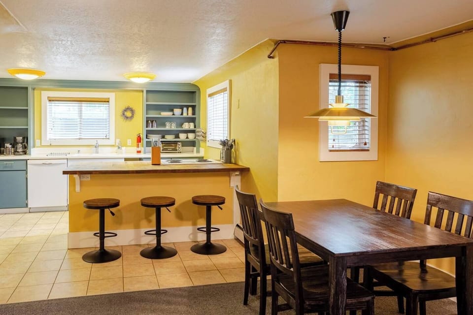 The bright and thoughtfully stocked kitchen features roomy bar seating adjacent to an open-concept dining and living room, ideal for gathering. 