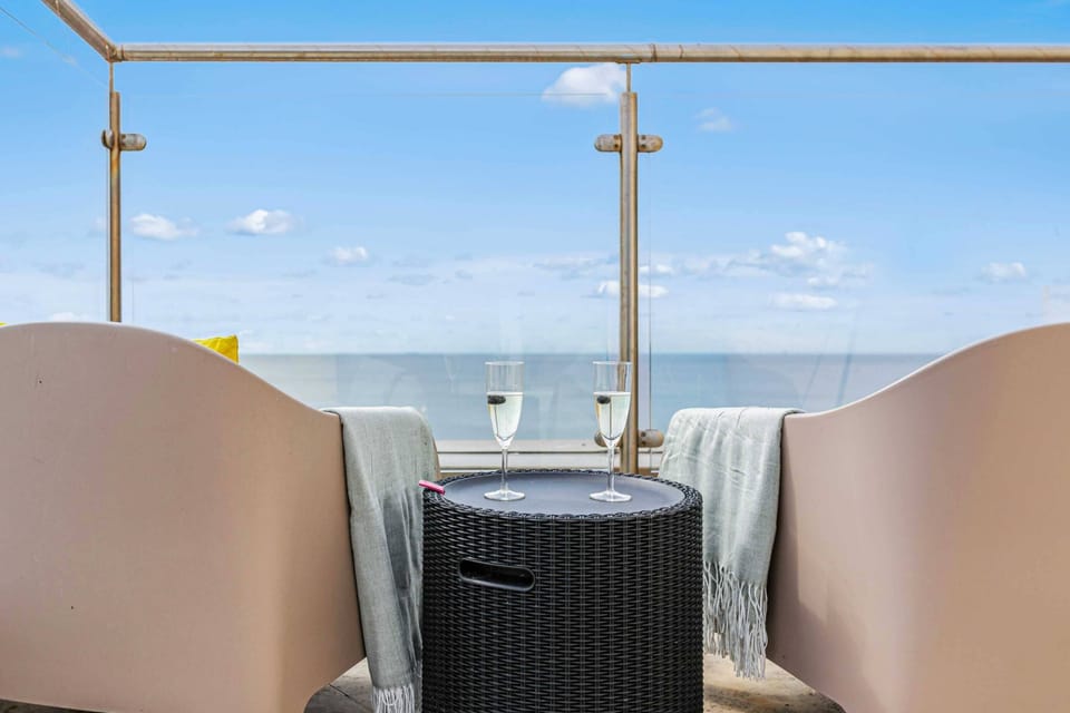 Cozy balcony seating with ocean views and champagne flutes, perfect for romantic moments