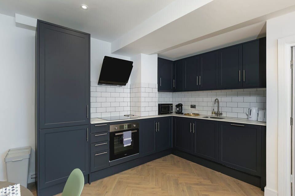 Modern navy kitchen with sleek white tile backsplash