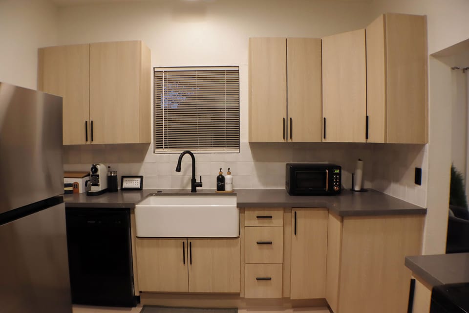 Modern kitchen featuring a farmhouse sink, updated appliances, and generous counter space.