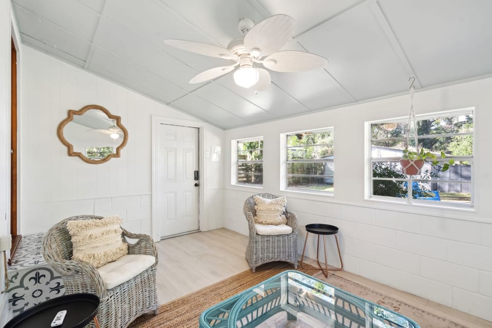In the back of the home is a sun room with a twin-sized day bed & 2 arm chairs