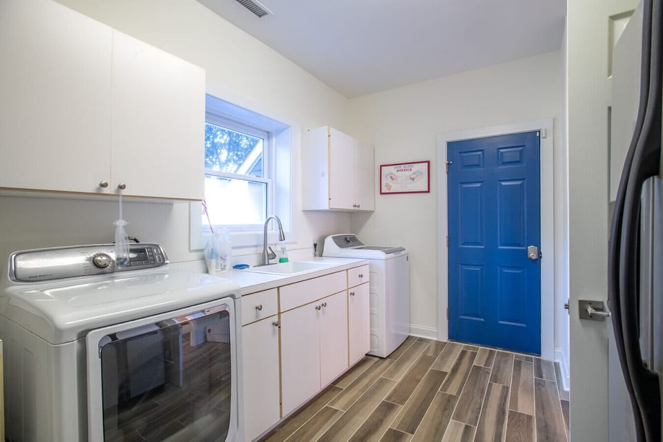 Spacious laundry area with washer, dryer, and sink for added convenience during your stay