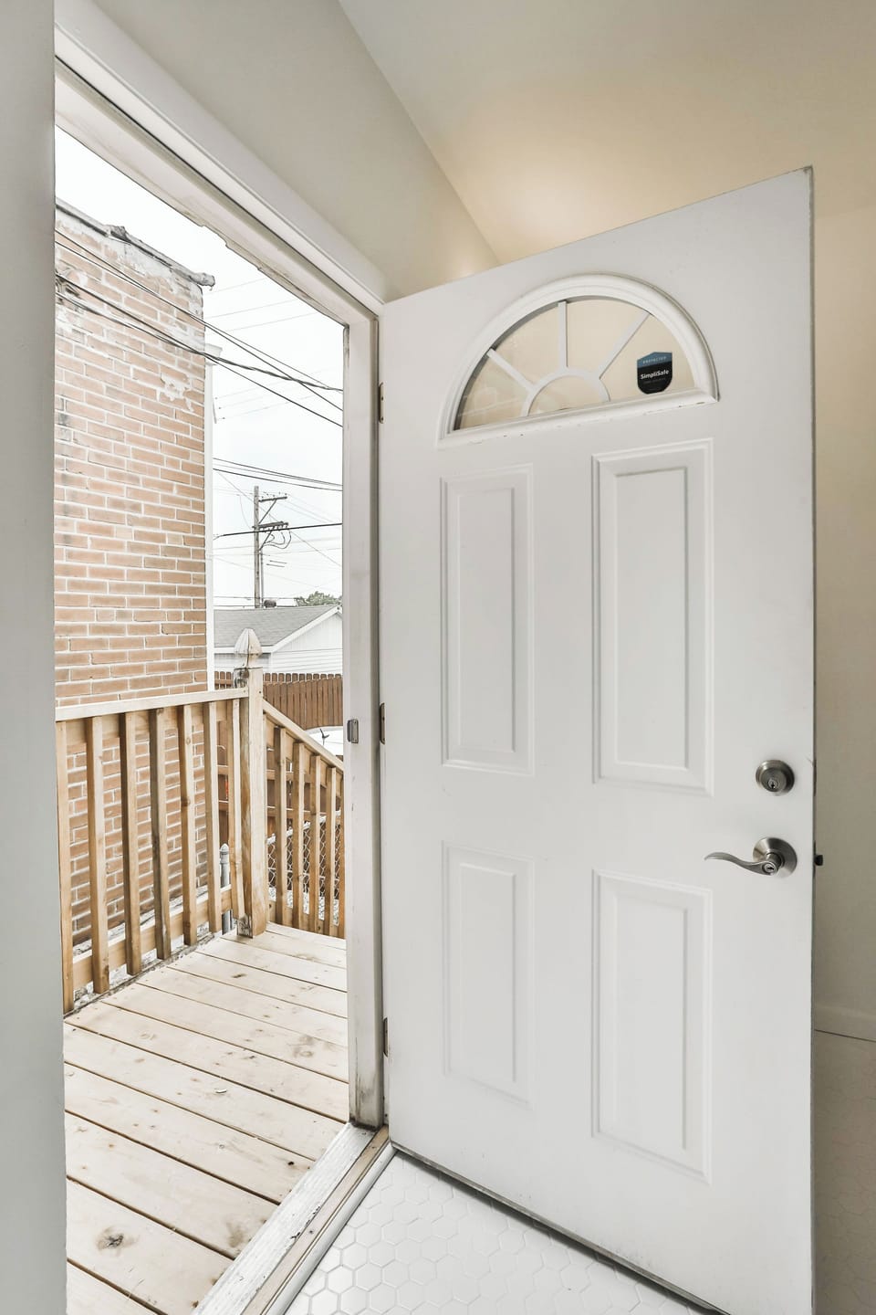 The open rear entry leads directly to a small wood landing with protective railing.