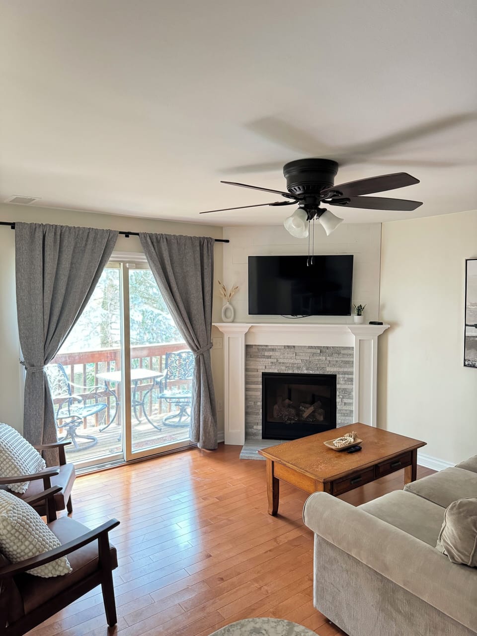 Living Room w/ Couch, Two Oversized Faux Leather Chairs, and a 50-inch Smart TV with Roku. 