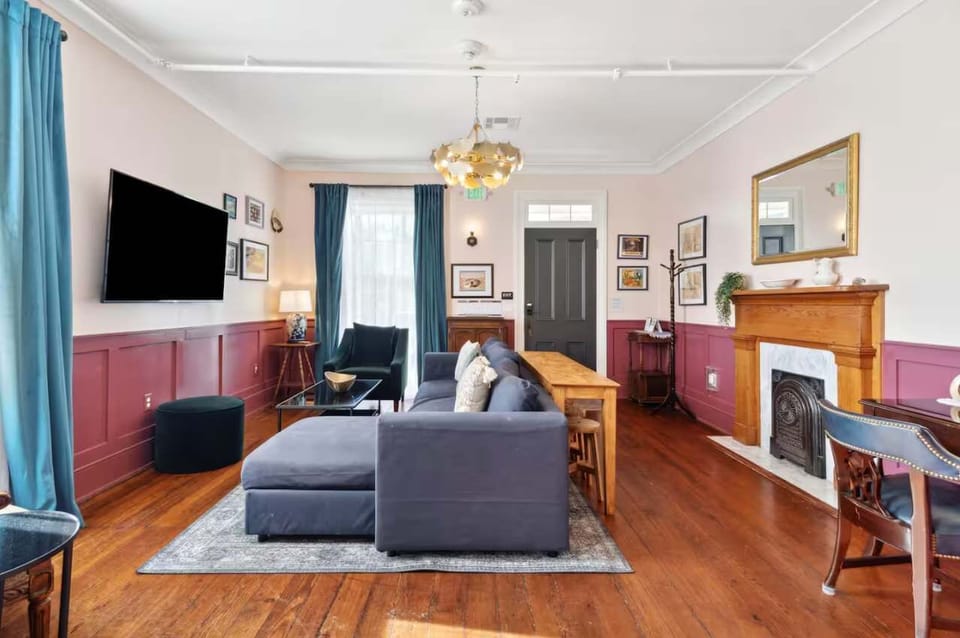 Living room with a comfortable couch, smart TV, and a small workspace with a desk and chair — perfect for relaxing or getting work done.