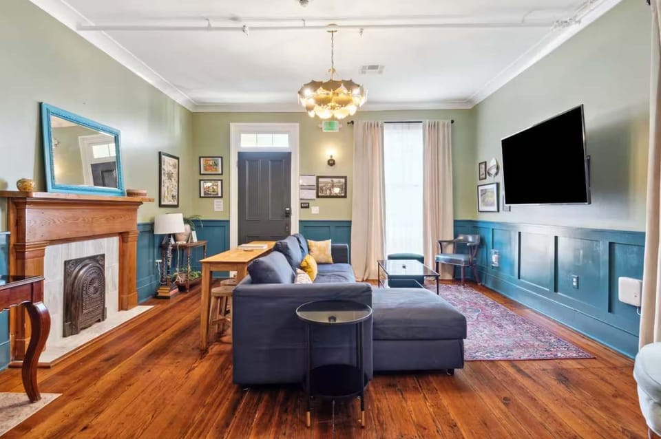 Living room featuring a comfortable couch, smart TV, and a small workspace with a desk and chair — perfect for relaxing or getting work done. (Left side unit)