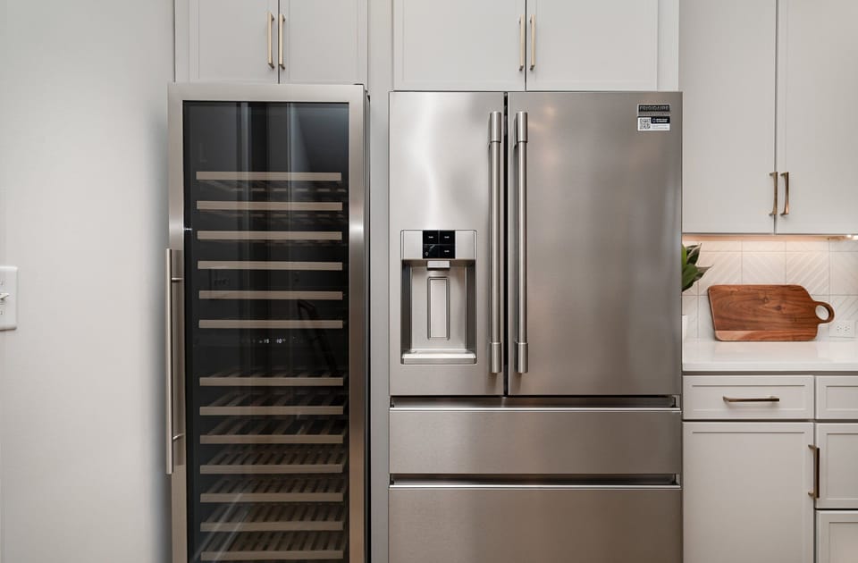 The fully open floor-equipped modern kitchen is stocked with all culinary essentials, stainless steel appliances, a wine fridge, and breakfast bar seating. (2nd Floor)