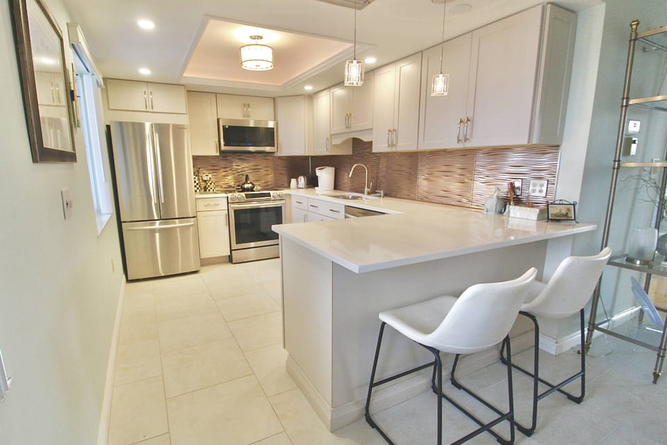The newly remolded kitchen boasts stainless steel appliances and island seating.