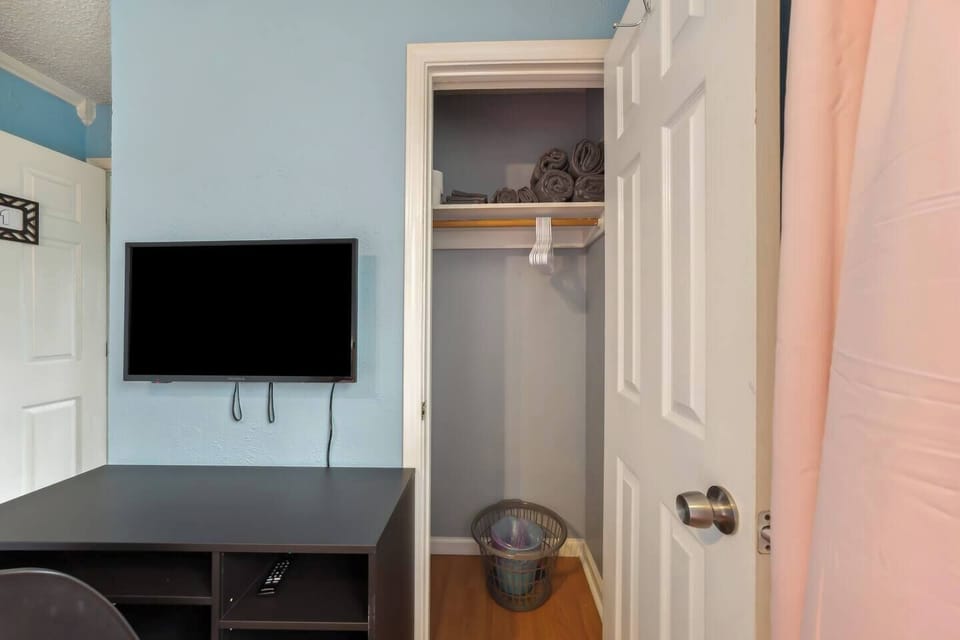 Smart TV, dresser, and spacious closet in queen bedroom