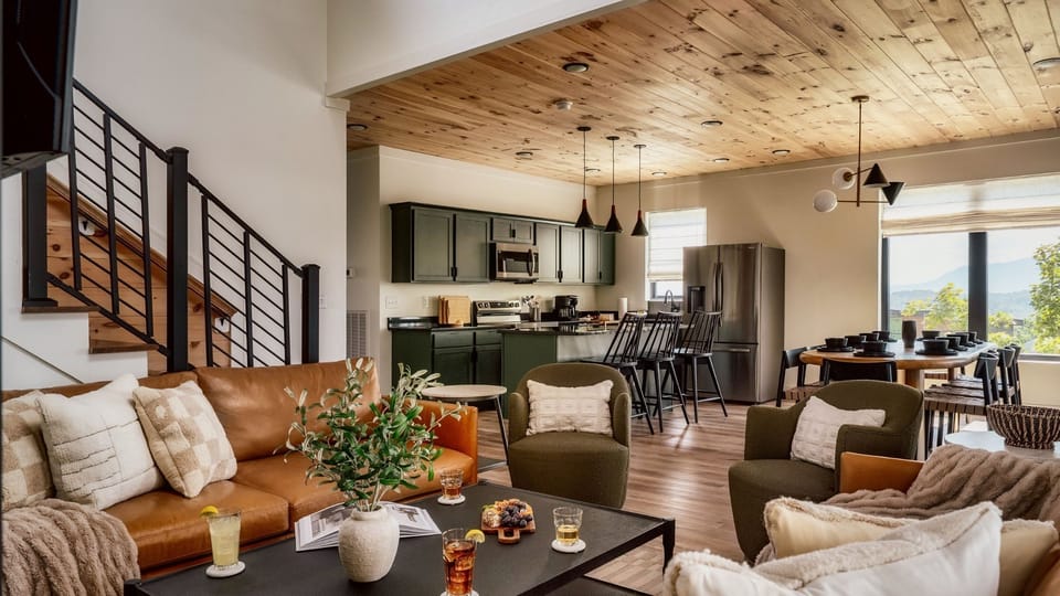 Large Cabin Rentals Smoky Mountain Sevierville Pigeon Forge Five - Main entry (middle level) living room, with modern, open kitchen, dining and living room. Living Room features gas fireplace, large SMART TV, and Wifi