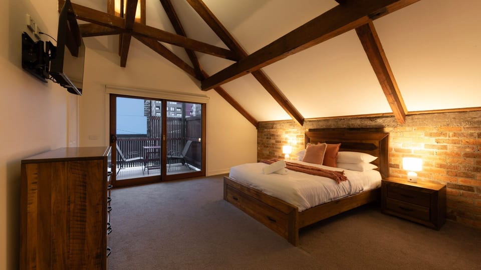 Character Loft Bedroom: Stunning master retreat boasting dramatic cathedral ceilings and exposed structural timber beams.