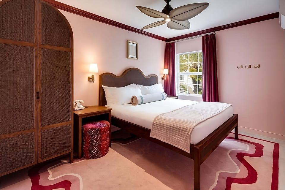Unwind in crisp linens beneath a stylish, airy ceiling fan.