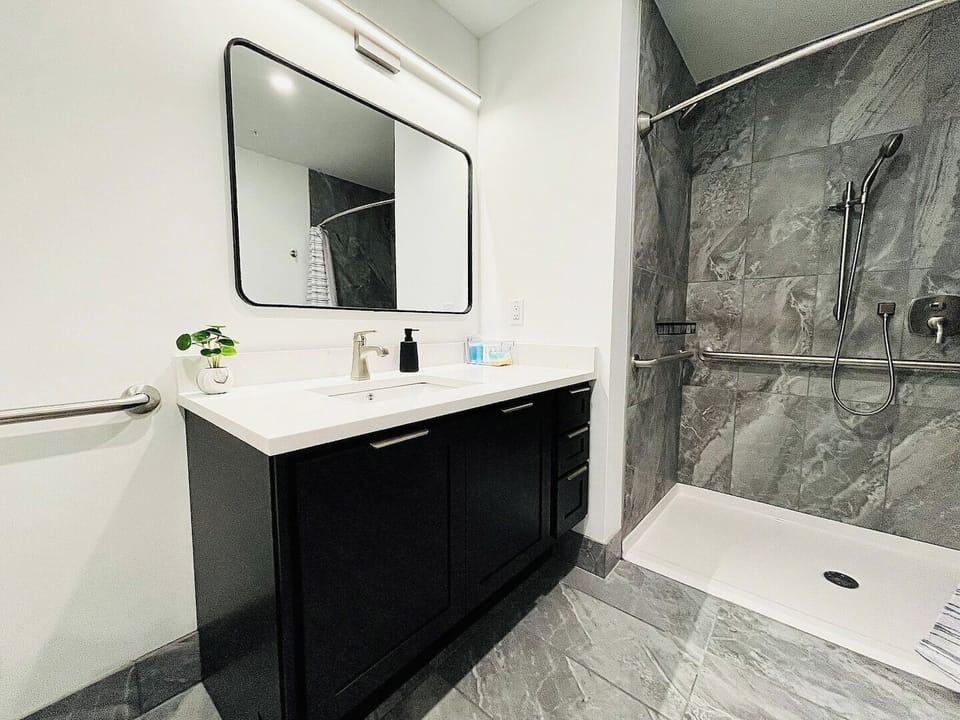 A sleek, modern bathroom with a spacious vanity, stylish lighting, and ample counter space. Spotlessly clean and well-lit, perfect for your stay.