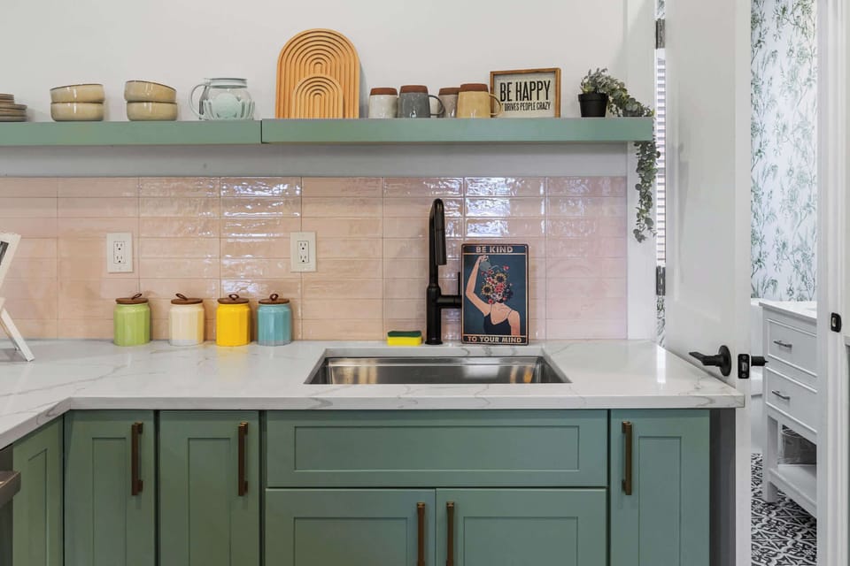 Step into this fully equipped kitchen with mint green cabinets, gleaming marble countertops, and stainless steel appliances. Cook, dine, and relax in style!