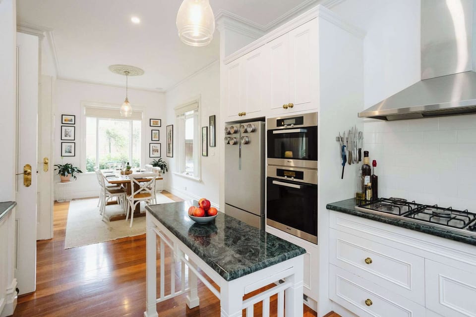 Open-plan kitchen and dining area, featuring modern appliances and a spacious layout, perfect for cooking and entertaining guests in a bright, inviting atmosphere